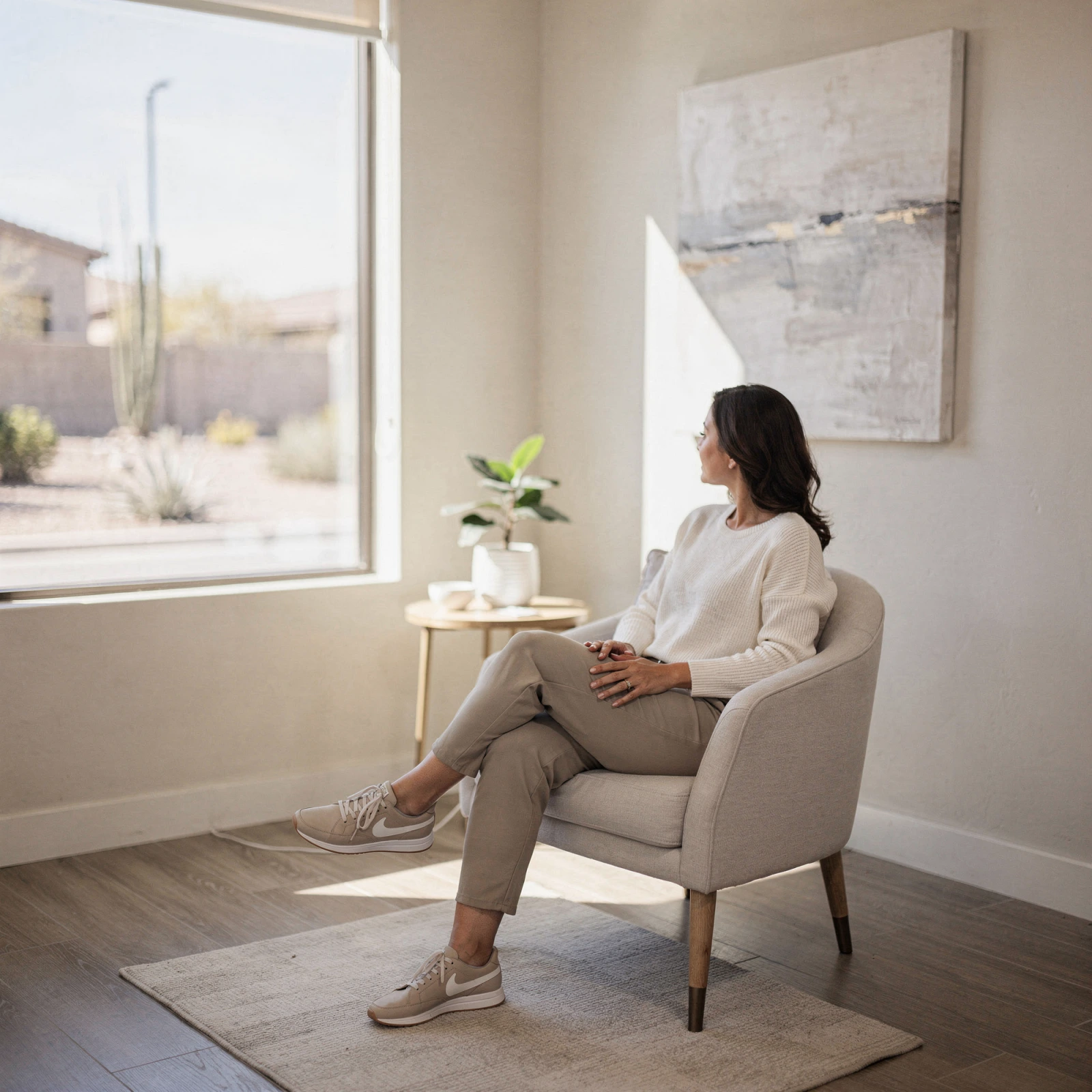 Patient sitting in a comfortable chair in a bright orthopedic clinic waiting room with desert views